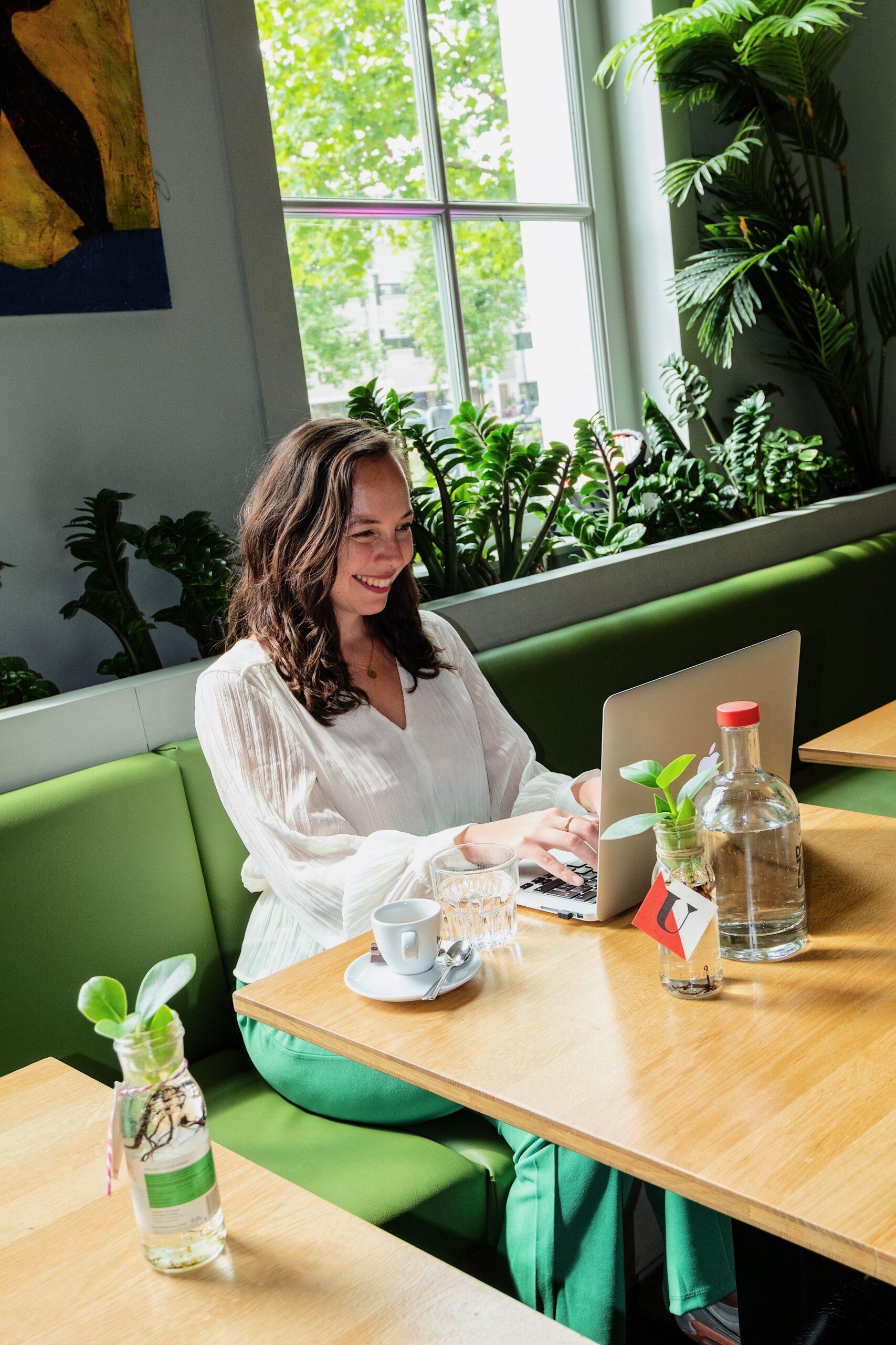 Vrouw met laptop en koffie tijdens een zakelijke afspraak bij De Utrechter in Utrecht.